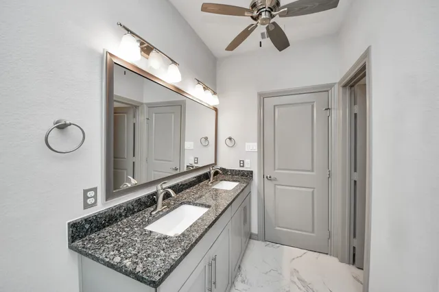 a bathroom with a granite countertop sink and a mirror