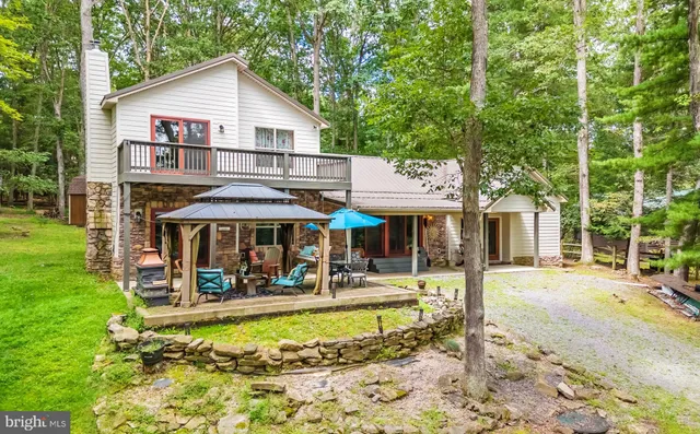 a view of a white house with a swimming pool lawn chairs and a yard