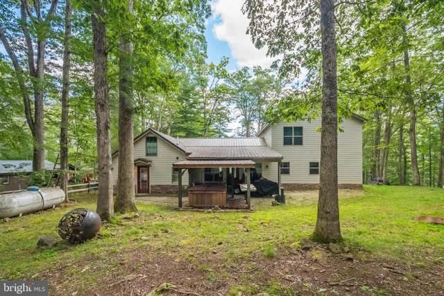 a view of a house with backyard and a tree