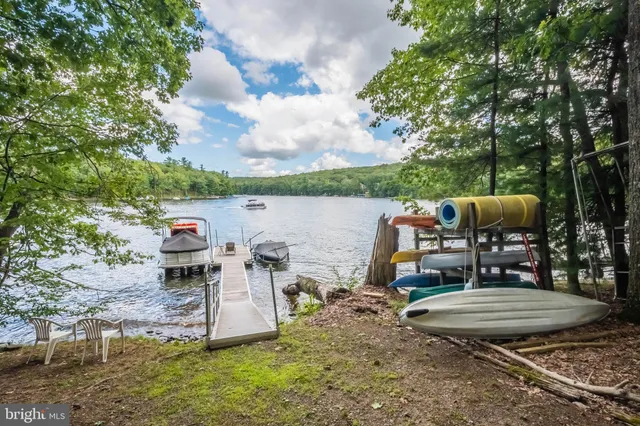 a view of a lake with a table and chairs next to a yard