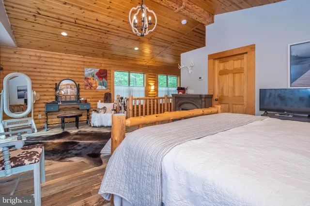 a spacious bedroom with a bed and wooden floor