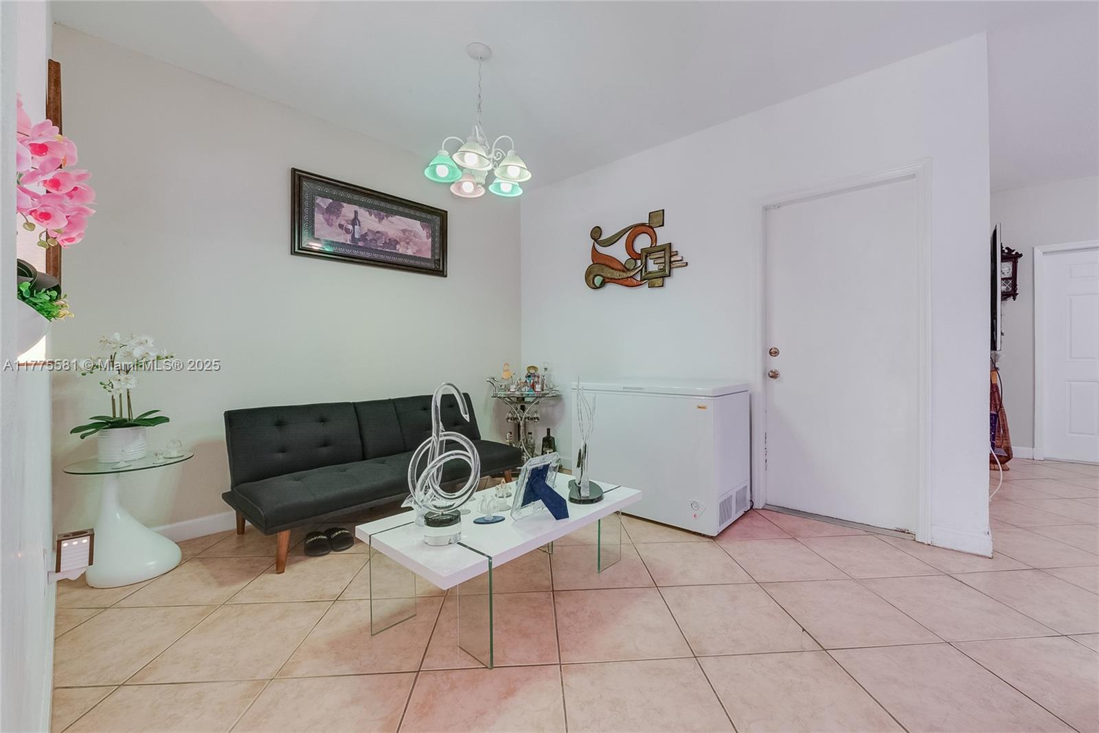 21441 Southwest 85th Path Cutler Bay, FL 33189 - Photo 4 of 17 a living room with furniture and a chandelier