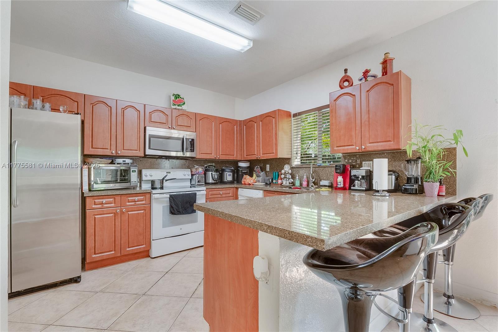 21441 Southwest 85th Path Cutler Bay, FL 33189 - Photo 7 of 17 a kitchen with stainless steel appliances a sink a stove and a refrigerator