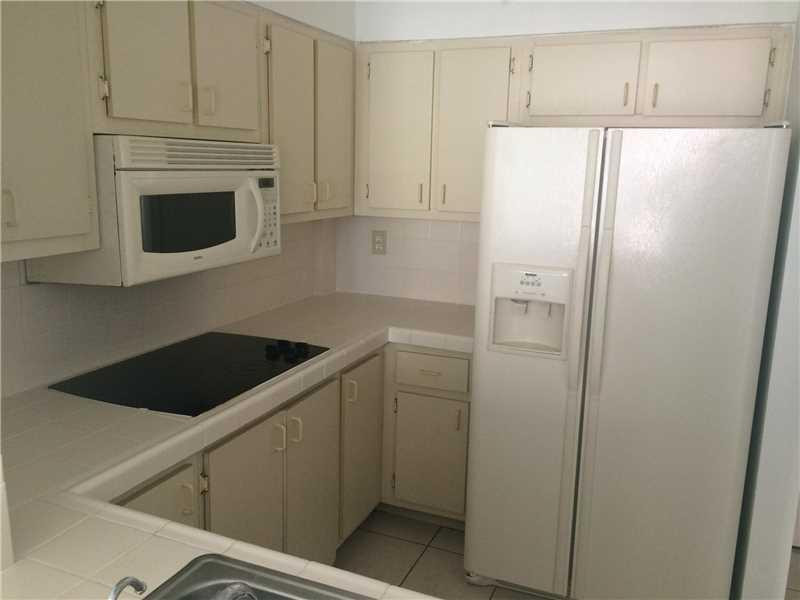 a kitchen with a refrigerator sink and cabinets