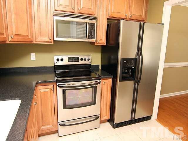 9826 Grettle Court Raleigh, NC 27617 - Photo 4 of 9 a kitchen with stainless steel appliances granite countertop a refrigerator and a stove