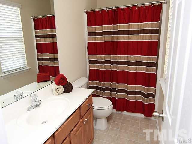 9826 Grettle Court Raleigh, NC 27617 - Photo 7 of 9 a bathroom with a sink and a mirror