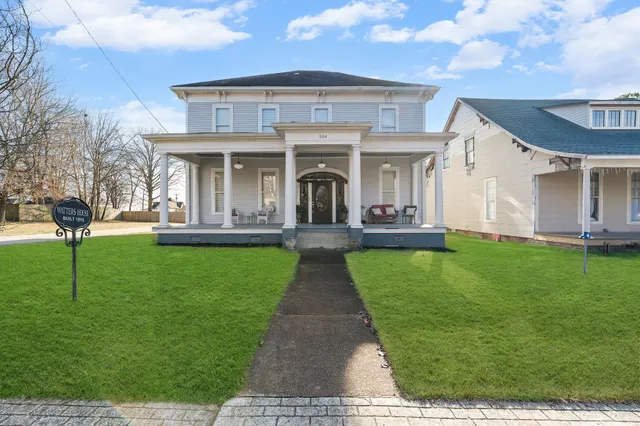 a kitchen with stainless steel appliances granite countertop a refrigerator a sink dishwasher a stove and white cabinets with wooden floor