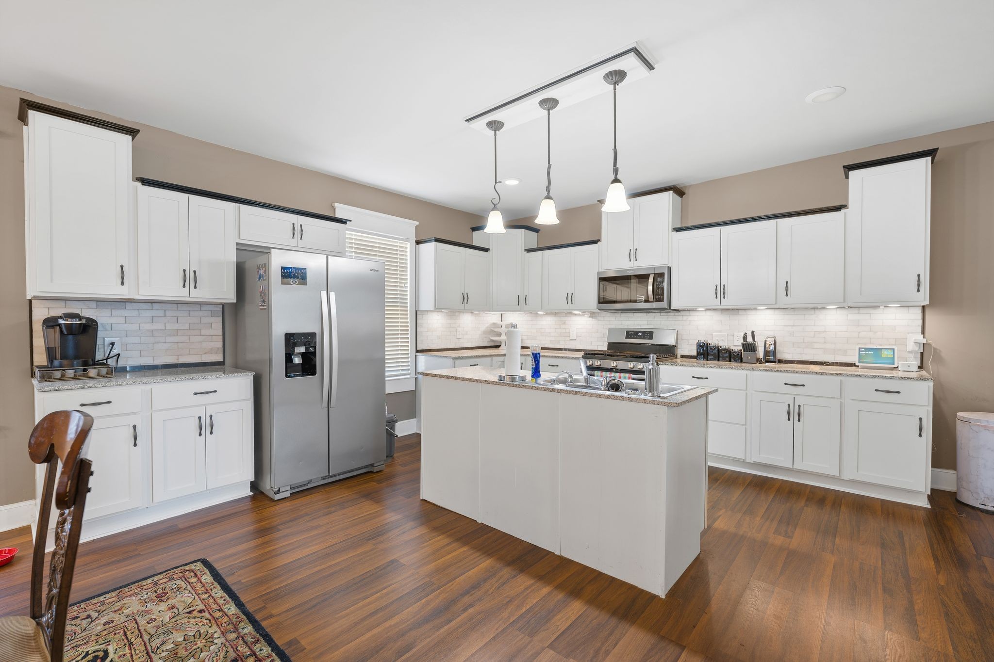 554 East Main Street Jackson, TN 38301 - Photo 2 of 38 a kitchen with stainless steel appliances granite countertop a refrigerator a sink dishwasher a stove and white cabinets with wooden floor