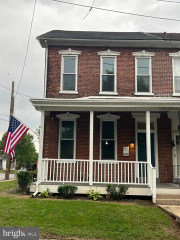 a view of a house with a small yard and wooden fence