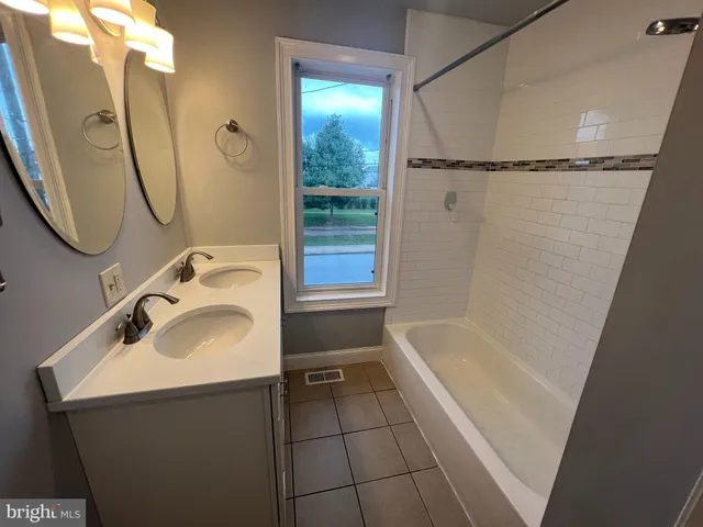 a bathroom with a sink a mirror toilet and bathtub