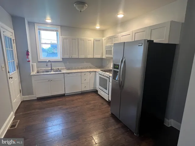 a kitchen with stainless steel appliances granite countertop a refrigerator and a sink
