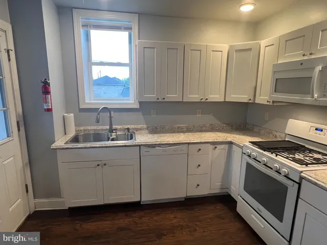 a kitchen with granite countertop a sink stainless steel appliances and cabinets