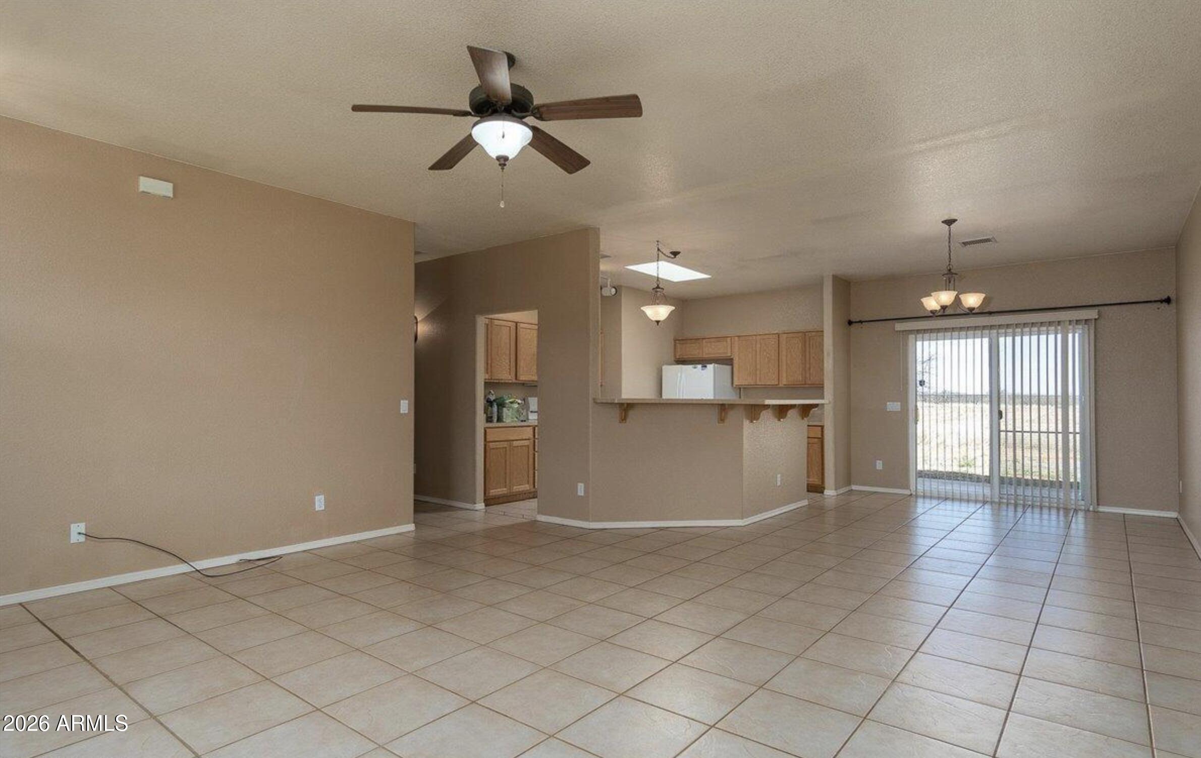 10193 East Windtalker Road Hereford, AZ 85615 - Photo 4 of 34 an empty room with wooden floor and windows