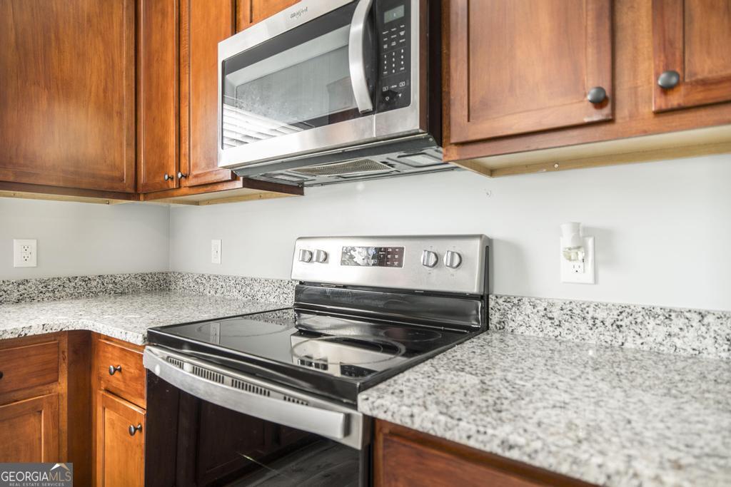 105 Browning Point Byron, GA 31008 - Photo 13 of 39 a kitchen with wooden cabinets and a stove top oven