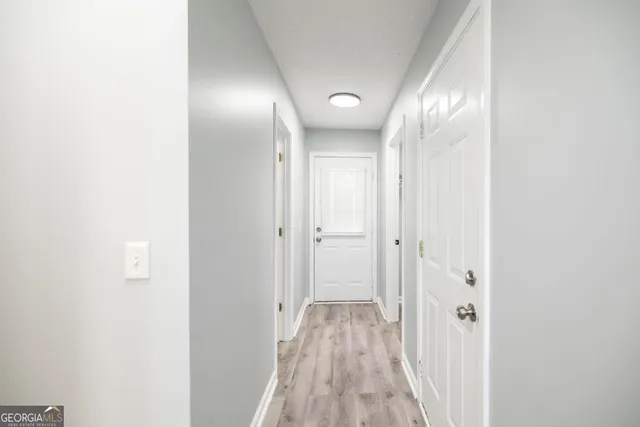a view of a hallway with wooden floor