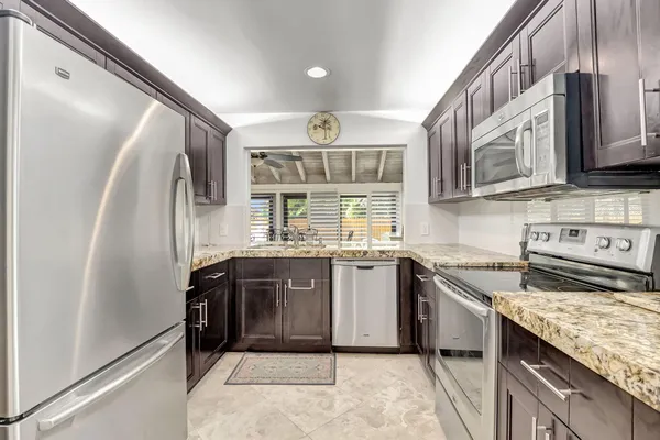 a kitchen with stainless steel appliances granite countertop a sink stove and refrigerator