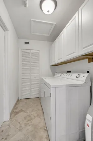 a utility room with cabinets washer and dryer