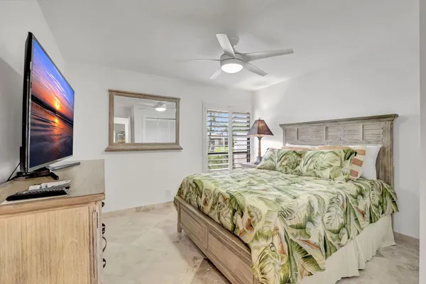 a bedroom with a large bed and a flat screen tv