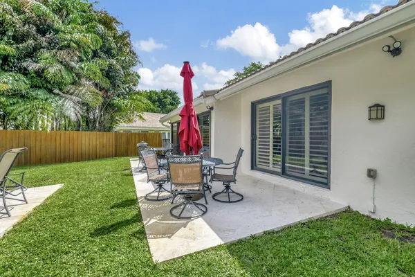 a view of a chair and table in backyard of the house
