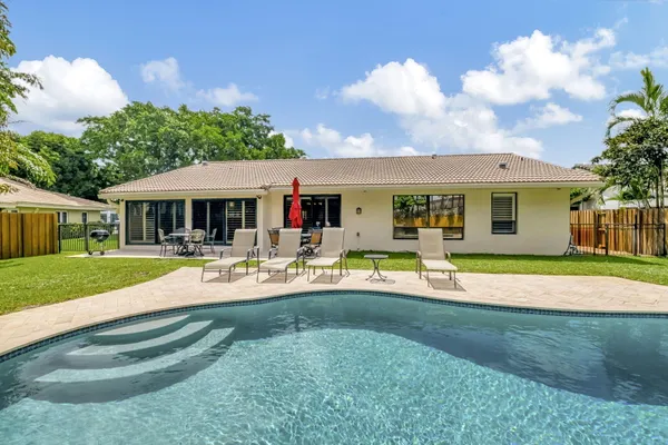 a view of a house with swimming pool and a yard