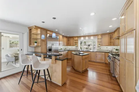 a living room with stainless steel appliances kitchen island granite countertop furniture a rug and a kitchen view