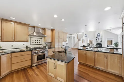 a kitchen with stainless steel appliances granite countertop a sink stove and refrigerator