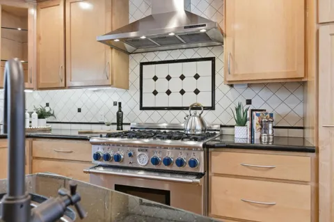a kitchen with stainless steel appliances granite countertop a stove and a cabinets