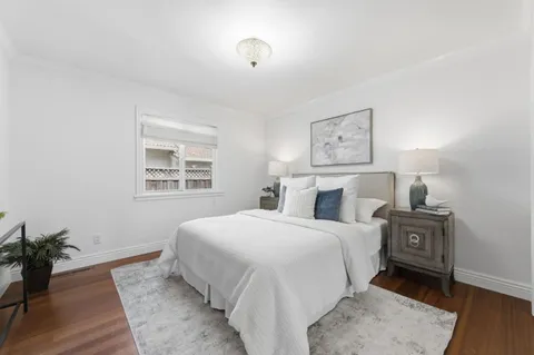 a bedroom with a large bed and a potted plant