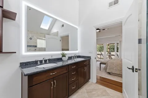 a spacious bathroom with a granite countertop sink and mirror