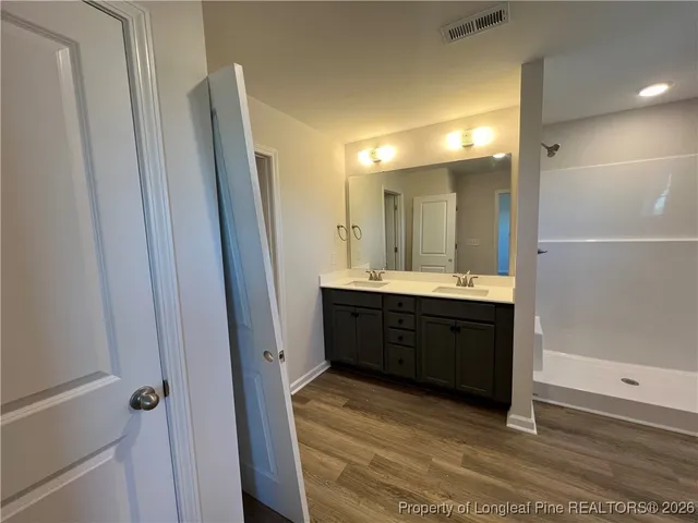a bathroom with a double vanity sink a mirror and a shower