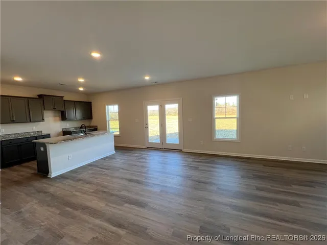 a view of kitchen with kitchen island granite countertop a stove top oven and a sink with granite countertops