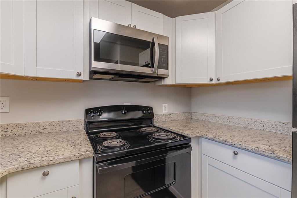 1376 Westmont Road Southwest Atlanta, GA 30311 - Photo 15 of 41 a kitchen with granite countertop a stove and a microwave