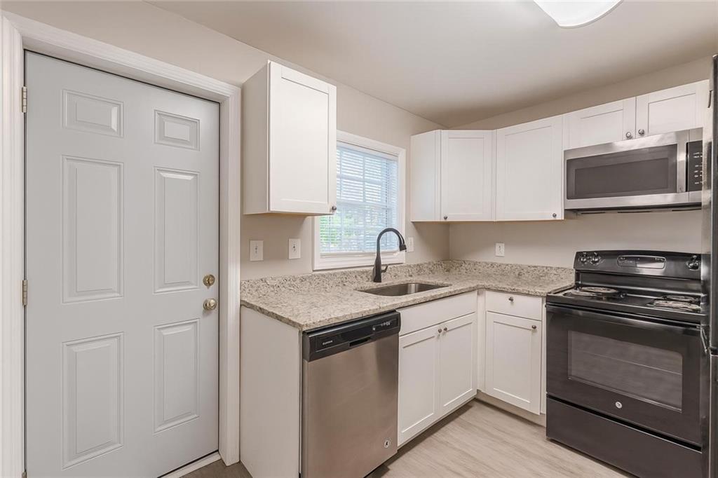 1376 Westmont Road Southwest Atlanta, GA 30311 - Photo 17 of 41 a kitchen with stainless steel appliances granite countertop a sink stove and microwave