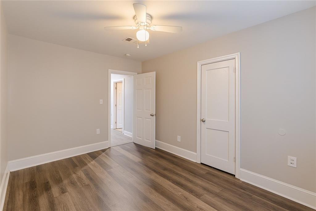 1376 Westmont Road Southwest Atlanta, GA 30311 - Photo 23 of 41 an empty room with wooden floor and fan