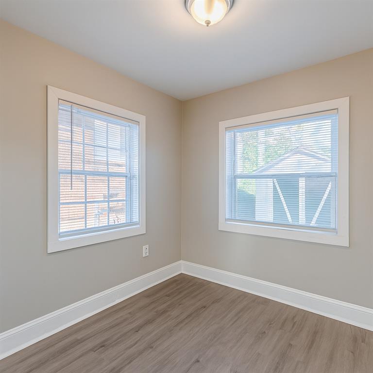 1376 Westmont Road Southwest Atlanta, GA 30311 - Photo 27 of 41 an empty room with wooden floor and windows