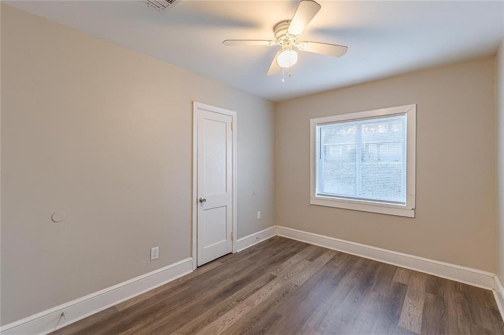 1376 Westmont Road Southwest Atlanta, GA 30311 - Photo 32 of 41 an empty room with wooden floor ceiling fan and window