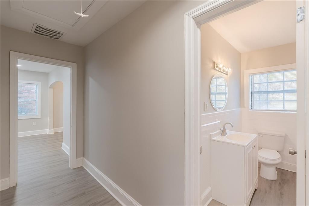 1376 Westmont Road Southwest Atlanta, GA 30311 - Photo 36 of 41 a bathroom with a granite countertop toilet a sink and a mirror