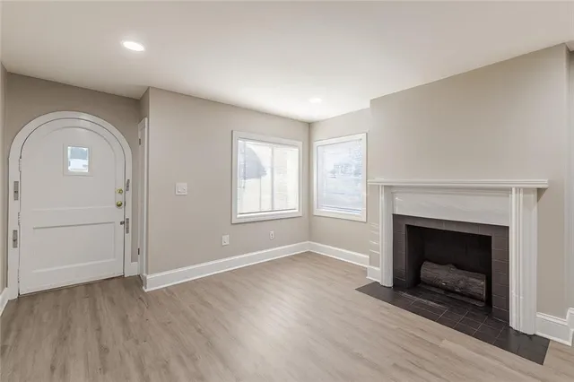 an empty room with windows and fireplace