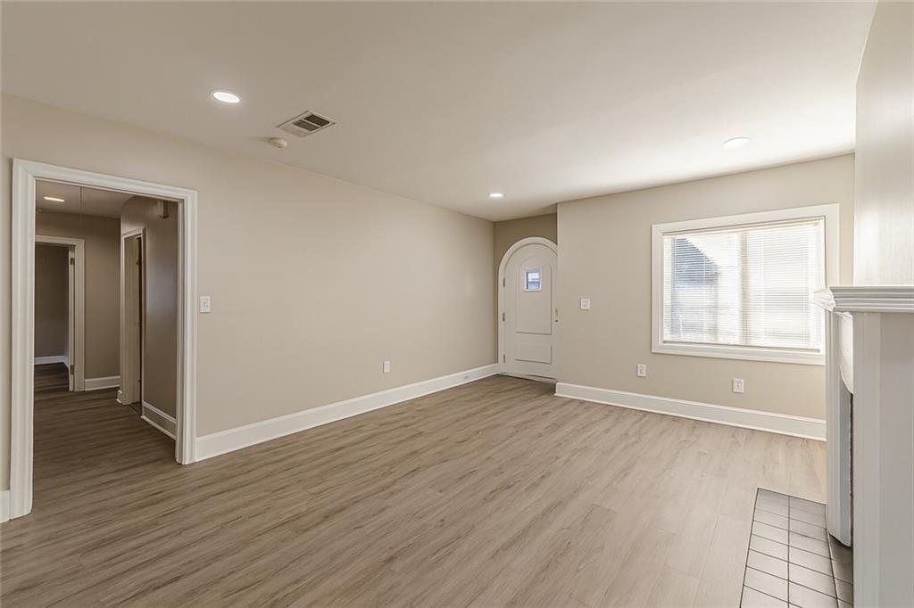 1376 Westmont Road Southwest Atlanta, GA 30311 - Photo 8 of 41 an empty room with wooden floor and windows