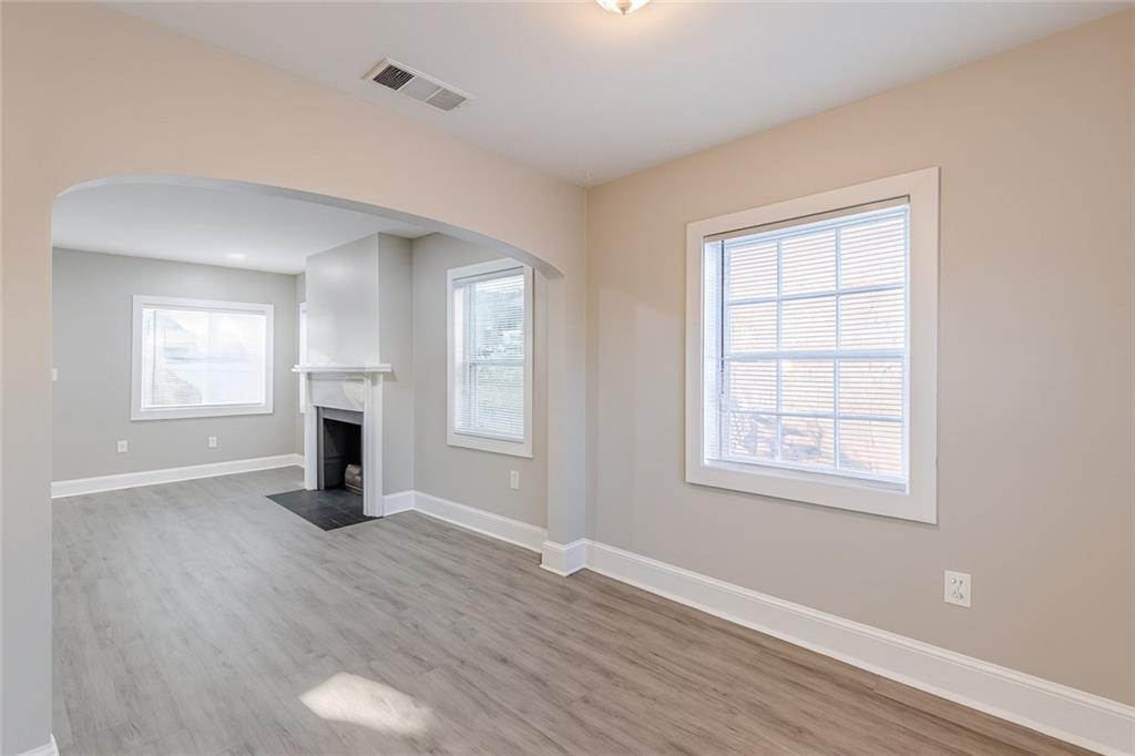 1376 Westmont Road Southwest Atlanta, GA 30311 - Photo 9 of 41 an empty room with wooden floor a ceiling fan and windows