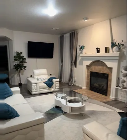 a living room with furniture a flat screen tv and a fireplace