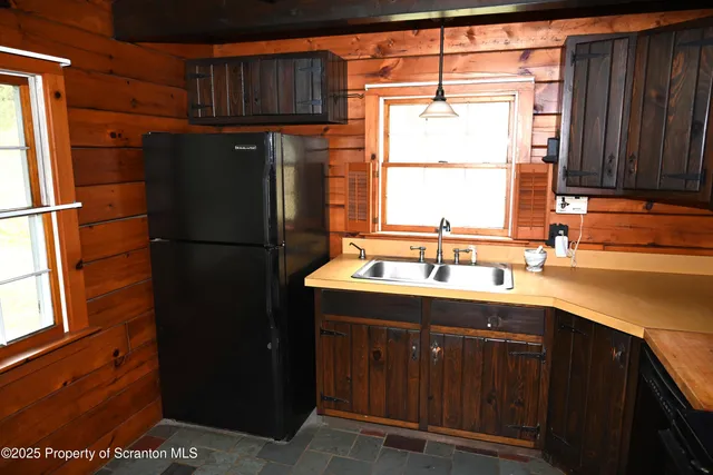 a kitchen with a sink a refrigerator and window