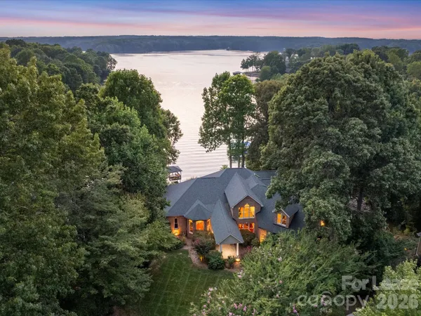 an aerial view of a house with a yard and lake view
