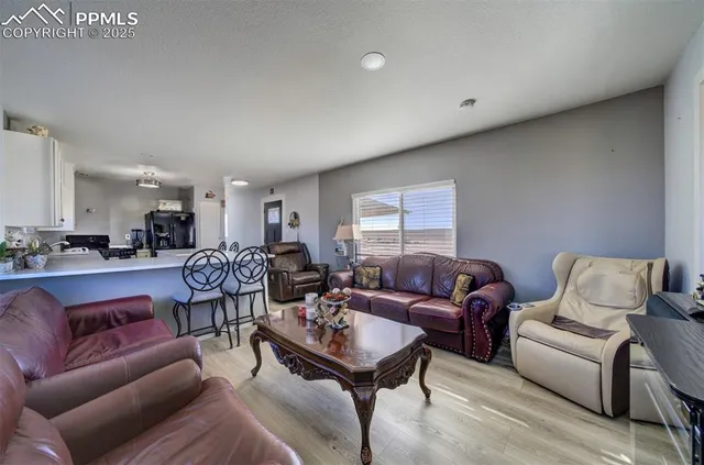 a living room with furniture a large window and a chandelier
