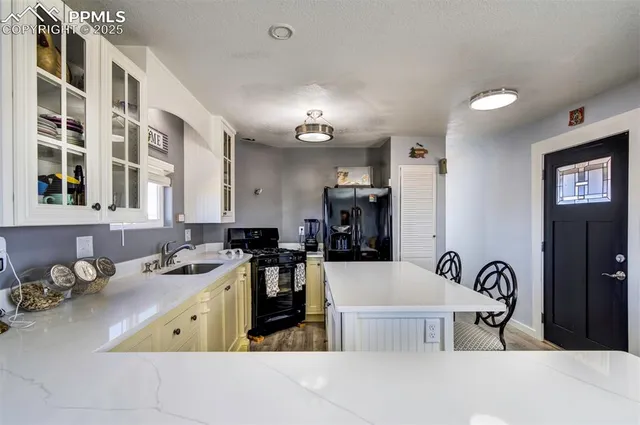 a kitchen with a stove a sink a dining table and chairs