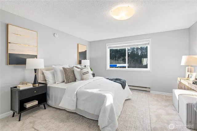 a bedroom with a bed and a lamp on dresser