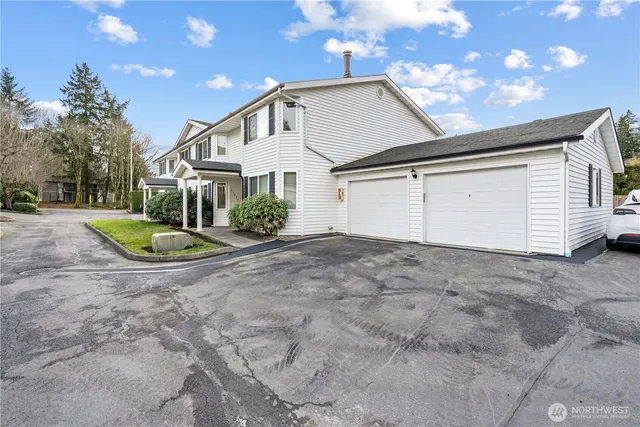 a view of a white house with a yard and plants