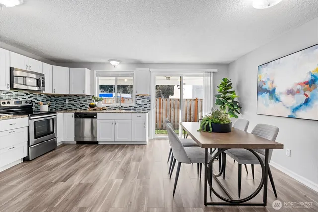 a kitchen with granite countertop white cabinets and stainless steel appliances