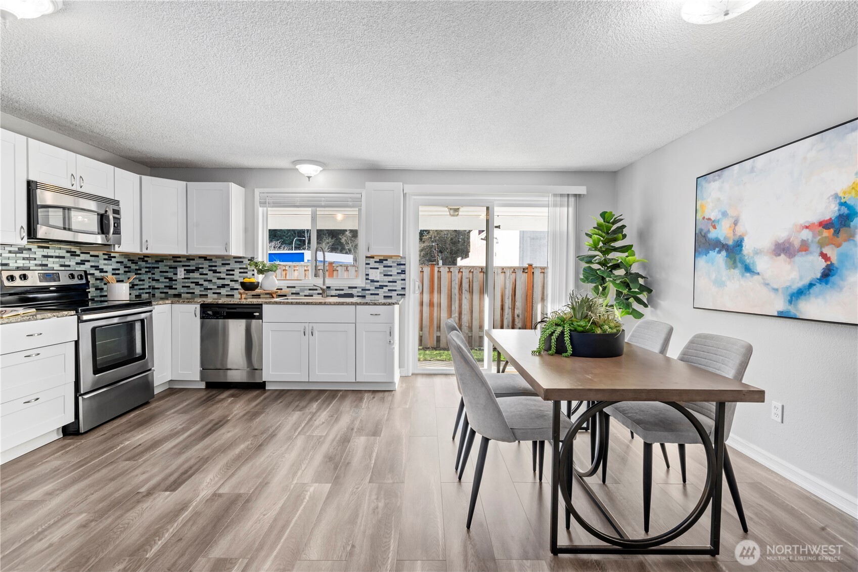 31921 46th Avenue Southwest Federal Way, WA 98023 - Photo 8 of 28 a kitchen with granite countertop white cabinets and stainless steel appliances