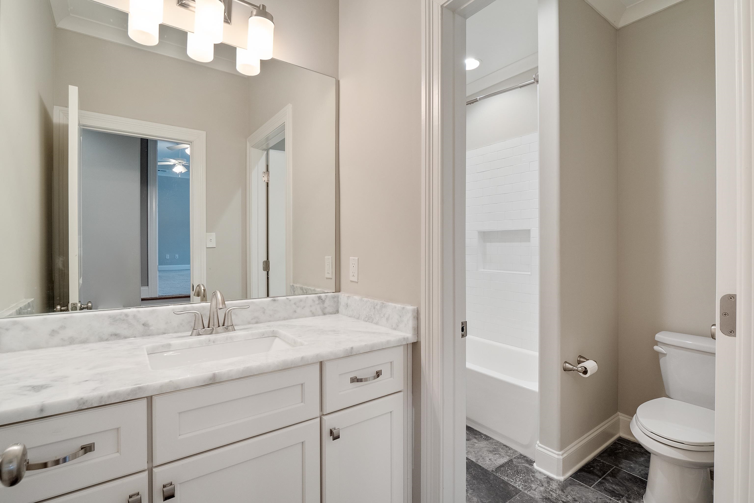 47 Addiegreen Cove Collierville, TN 38017 - Photo 20 of 34 a bathroom with a granite countertop sink a toilet and a mirror